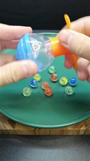 The glass marbles collide, creating a sound.