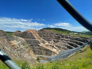 The town of Lead (pronounced Leed) is just 8 miles away from the climbing in Spearfish, SD. Right behind some grass and picnic tables is the Homestake Mine, the deepest (8250 feet), largest and most productive (lifetime production of $72 billion) gold mine in the western hemisphere before it closed in January 2002. It was originally owned by George Hearst (father of William Randolph Hearst). There’s now an underground lab running research experiments on dark matter and neutrino physics. Just 3 m