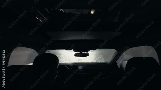 POV wide footage of Driver inside vehicle entering automatic car wash with visible interior view and glass roof.