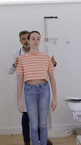 Professional healthcare worker performing detailed posture assessment, analyzing spine alignment and potential musculoskeletal conditions in clinical environment
