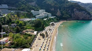 Agios Gordios exotic beach in Corfu island,Greece. Agios Gordios beach, Corfu island, Greece. Panoramic view of the Agios Gordios beach, sandy seashore with beach umbrellas and deck chairs.