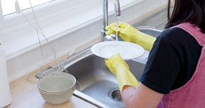 Children, learning and cleaning in a kitchen with girl washing dishes and bonding with sister in their home. Family, gloves and kids helping with housework, hygiene and bacteria prevention