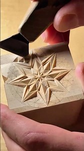 Carving a geometric star pattern into a wooden block using a sharp chip carving knife