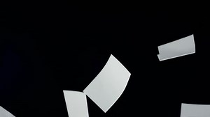 Blank paper sheets falling down, slow motion clip
