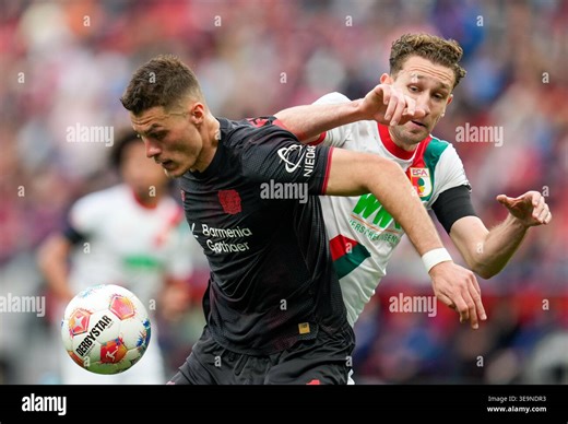 April 18, 2026, Leverkusen, Germany: Bayer Leverkusen forward PATRIK SCHICK (14) against Augsburg defender ARTHUR CHAVES (34) during the match between Bayer 04 Leverkusen and FC Augsburg in the 1. Bundesliga on April 18, 2026, in Leverkusen, Germany...DFL REGULATIONS PROHIBIT ANY USE OF PHOTOGRAPHS AS IMAGE SEQUENCES AND/OR QUASI-VIDEO (Credit Image: © Scott Coleman/ZUMA Press Wire) EDITORIAL USAGE ONLY! Not for Commercial USAGE! Stock Photo - Alamy