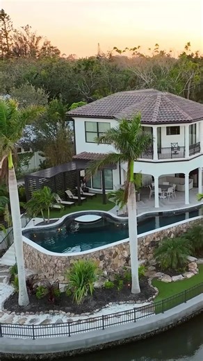 The challenge of this unique project was to elevate the new pool to make it more usable for the entire family. It is a disguised lap pool with a freeform shape that follows the minimum setbacks from the water, creatively making the pool as big as possible. It's backed with a blend of modern features and a timeless rock wall. #insanepools #lucaslagoons #pool #backyard