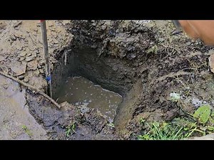 Using pressure washer to dig a fence post hole.