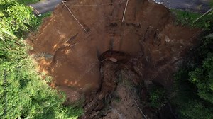Top-down aerial shot from bottom to height of local landslide aftermath. Steep bluff after ravine side collapsed. Natural calamity caused by heavy rains and small earthquakes at central Bali