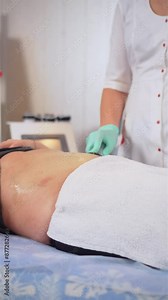 Body cavitation treatment. Vertical video. Hardware cosmetology. Woman getting anti cellulite and anti fat therapy in hospital. Ultrasound cavitation body contouring treatment