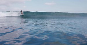 Woman surfer rides on the ocean wave. Beautiful surf girl during surfing