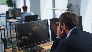 Financier frustrated financial loss looking stock market charts at multiple monitors closeup. Forex trader losing money on crypto exchange sitting office open space. Stressed investor analyzing graphs