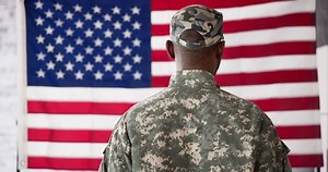 clip-1098986487-rear-view-military-man-saluting-us-flag