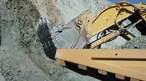 Excavator digger digging limestone in open pit mine. Development opencast for mining minerals. Mining excavator with electric shovel, slow motion