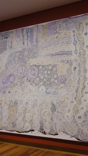 Ngangkari artist Betty Muffler and her niece, Maringka Burton collaborated on this painting together. In it, they reflect on the Country where they were born and belong. Maringka paints Anumara Piti, the caterpillar tjukurpa site with the big rock holes and the linking paths taken by the green Anumara caterpillars. Betty paints an emu site named Yalungu. 𝘕𝘨𝘢𝘯𝘨𝘬𝘢𝘳𝘪 𝘕𝘨𝘶𝘳𝘢 (𝘏𝘦𝘢𝘭𝘪𝘯𝘨 𝘊𝘰𝘶𝘯𝘵𝘳𝘺) was commissioned by the University of Melbourne with funds donated by Peter and R