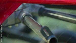 A few tractors are working on the fields and they are preparing hay. We can see the machine raking hay.