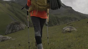 Download close up tracking back view woman hiker with poles hike high in scenic mountains nature for free