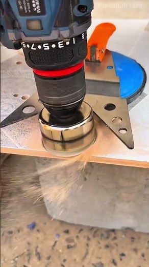 Drilling a precise round hole into a ceramic tile using a large diamond hole saw drill bit