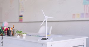 Renewable energy, wind turbine and classroom at school, innovation and windmill model on table for sustainability. Eco friendly, environment and stationary on desk for student learning and education