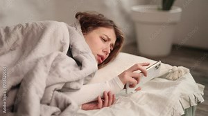 Shocked young woman using smartphone gadget for checking morning news and notifications after wake up on sofa at home Upset female reading negative information on cellphone Bad message concept