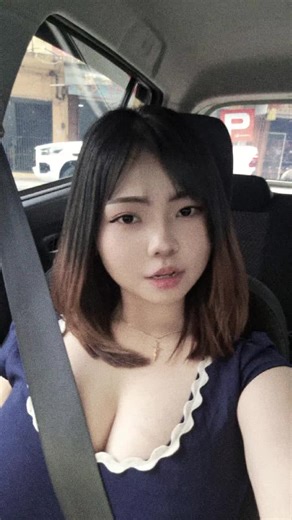 Urban Car Ride: Woman in Blue Top Adjusts Hair