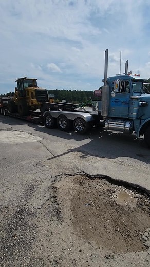 Blue Semi-Truck Transporting Yellow Construction Vehicle