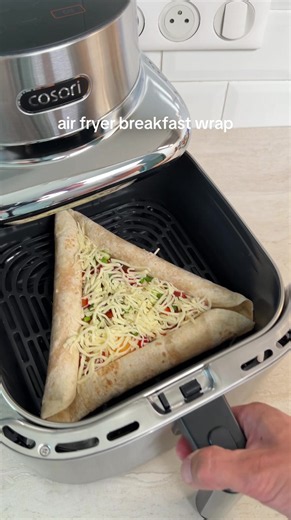 air fryer breakfast wrap sausages wrapped into the tortilla edges, filled with eggs, tomatoes, bell peppers, green onion and melty cheese in the center air fry at 190C/374F for 10 minutes easy and delicious #airfryerrecipes #breakfastwrap #breakfastrecipes #tortilla #foodtok