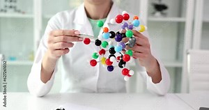 Scientist is holding molecular structure model and pointing out molecule. Science education and chemical research concept