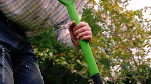 Gardener digging garden with spade medium