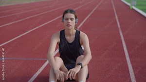 Female runner stretches her muscles in preparation for running on the treadmill around the soccer field.