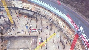 Construction of a neo-futuristic building with a translucent facade, in the Skolkovo Innovation Center Russia, Moscow. Top view from a drone on a building and construction cranes.