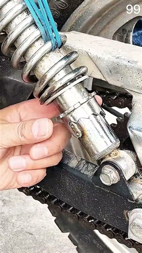 Motorcycle shock absorber held, coil spring shows rusted wear