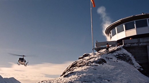 On this day in 1968, director Peter R. Hunt shot part of the attack sequence on Piz Gloria for ON HER MAJESTY’S SECRET SERVICE. Due to the altitude and high winds the helicopters couldn’t land so the stuntmen had to jump out of the choppers instead. Stunt coordinator Richard Graydon said: “You didn’t know exactly how far you were going to sink into the snow. And being fairly small I found myself up to my nose, so just the top of my hat was visible.” | James Bond 007