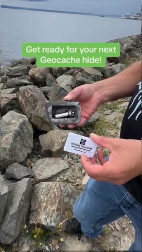 🤘 Look at this rockin’ geocache! 🤘 See all our devious cache containers @shop_geocaching! Video: A geocacher stands next to large rocks on the edge of the water. They hold a fake geocache rock container up to the camera and show it is hollowed out in the back with a bison tube inside. They close the container and then replace the cache between the other rocks. #geocaching #geocache #sneaky #devious #nature #explore | Geocaching