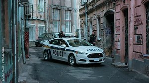 Dangerous situation police with pistol fight for a criminal street near patrol car burglar crime hold danger gangster gun robber uniform illegal law bad guy close up slow motion