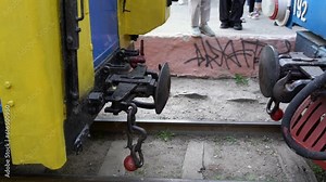 Close-up detail of iron connection of two train wagons before docking. Slow motion of railway car coupler and train buffers. Buffers and chain coupler on children railway - wagon coupling moment in HD