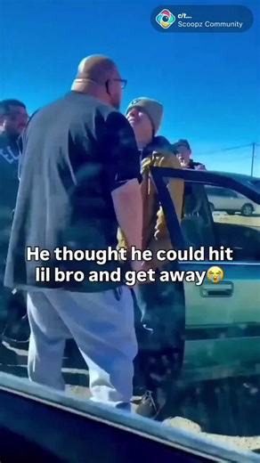 This big dude decided to get in the face of this smaller guy and thought he could lay hands on him shoving him into the car. He didn't know this guy was ready to defend himself and talks off running.