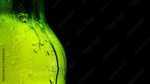 Drop of condensate drips on beer bottle glass 4k close-up slow-motion video. Water drops falling down on black background