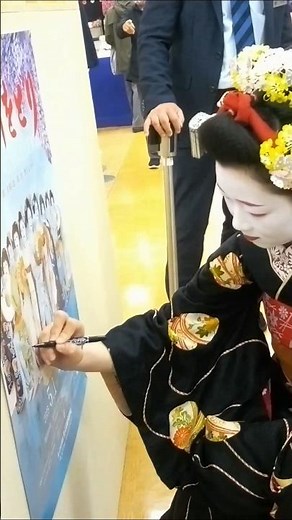 丸広百貨店の川越店「大京都展」 京都・先斗町の舞妓・もみ智さんが踊りの合間に、「大京都展」催事会場のパーテーションに掲示されていた「第186回 鴨川をどり」のポスターのご自分のお姿の所にサイン