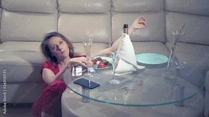 woman gets drunk at home alone at a table set for two for a romantic date, as her partner did not come on a date