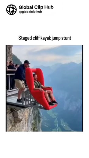 Global CLIP HUB on Instagram: ""Extreme stunt video: Person in red inflatable kayak pushed off high cliff, landing on giant inflatables below. Heavily watermarked for Bitz.io crypto casino promo. Caption notes it's likely AI-generated/CGI (common in 2025 viral extreme sports clips per studies), with anomalies giving it away."
