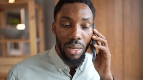 clip-4003847137-entrepreneur-talking-on-smartphone-while-working-home