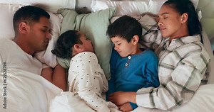 Relax, love and children sleeping with their parents in bed for cuddling in their family house. Sweet, bonding and top view of sibling kids taking nap with their mother and father in bedroom at home.