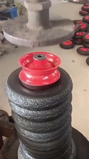 someone is installing a rim on a tire using a machine tool