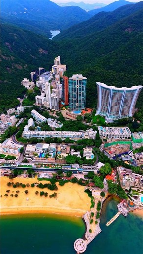 Golden sand, turquoise water, and Repulse Bay’s iconic towers rising against lush green mountains.