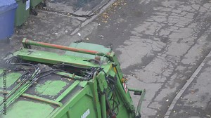 garbage truck loading the contents of containers during the day in the city. Removal of household and food waste from containers