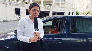 Female News Reporter Reporting Outside a Car