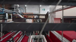 Machinery processing the eco material at the plant. Automated machinery cutting the eco fabric material. Machinery manufacturing accessories using the red eco friendly material. Textile.