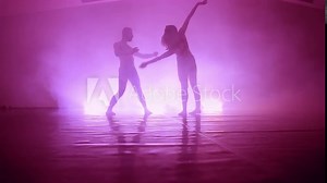 Emotional and graceful modern ballet dance performed by couple in smoky studio