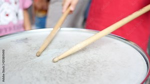 Children play drum with drumsticks - music instrument demonstration for kids
