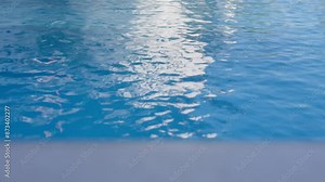 Close-up of a swimming pool water surface showing light reflections and gentle ripples